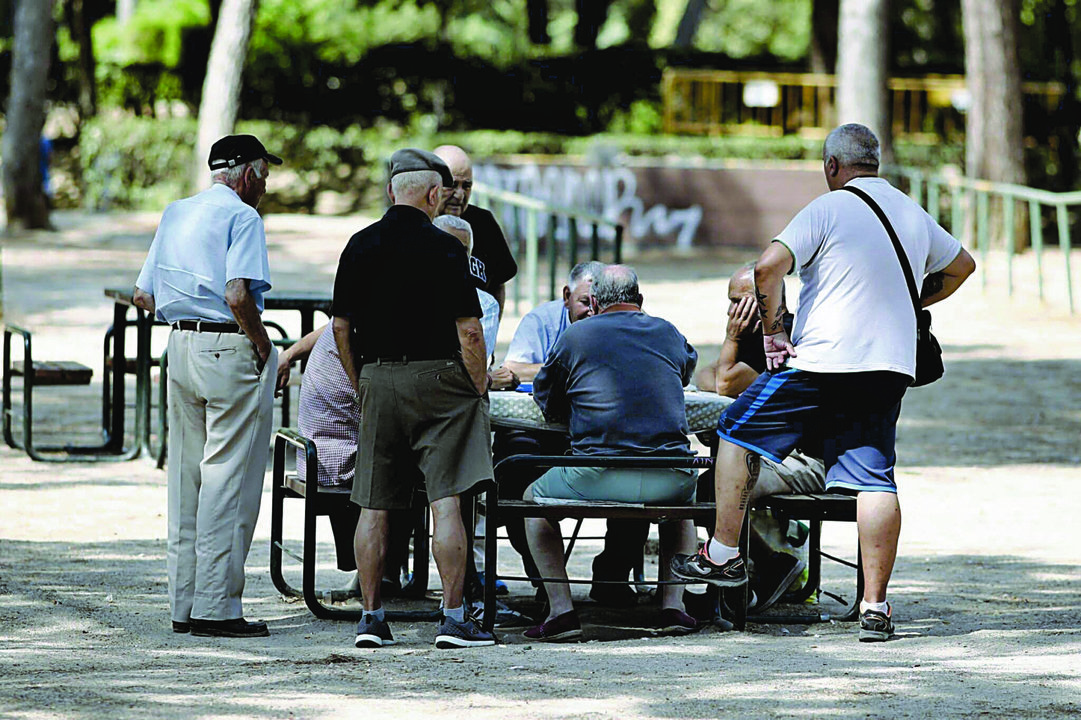 Varios pensionistas jugando al dominó en un parque de Madrid.
